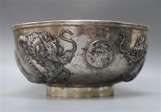 A late 19th/early 20th century Chinese Export white metal bowl, embossed with two dragons chasing a pearl,